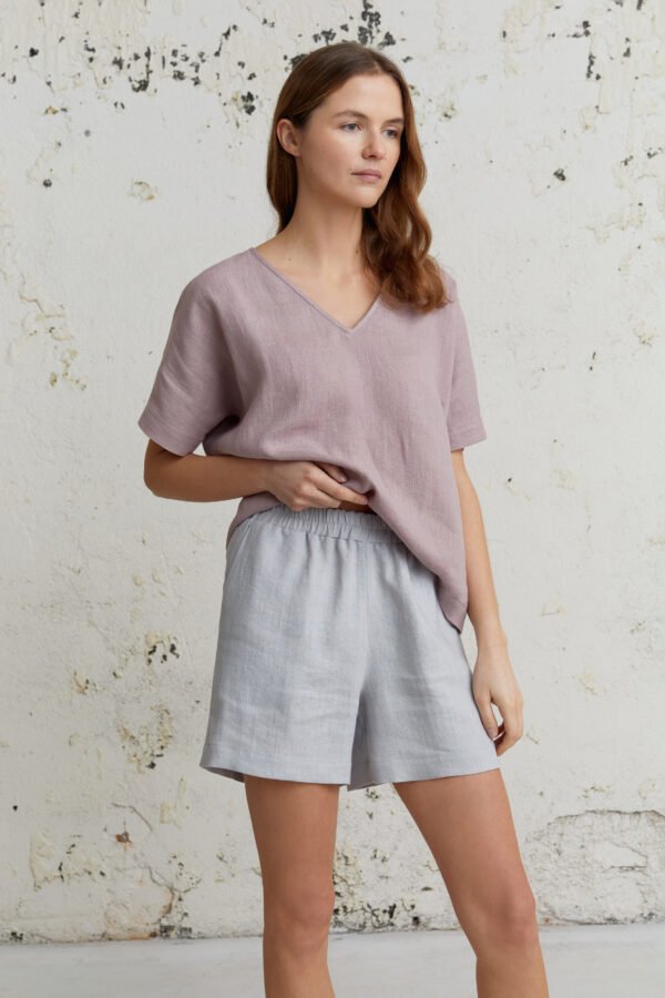 Adatyte lininiai šortai šviesiai pilkos spalvos su šviesiai violetine palaidine – elegantiškas ir natūralus įvaizdis.
