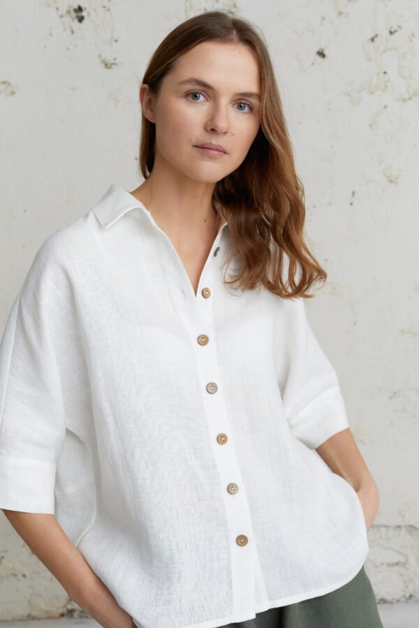 Laisvo silueto balti lininiai marškiniai – natūrali medžiaga, lengvas kritimas ir patogumas.
