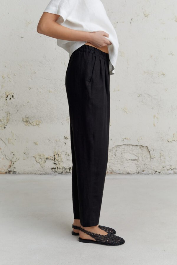 Tvarios juodos lininės kelnės su guma ir kišenėmis iš Adaytė, laisvas ir elegantiškas moteriškas stilius.